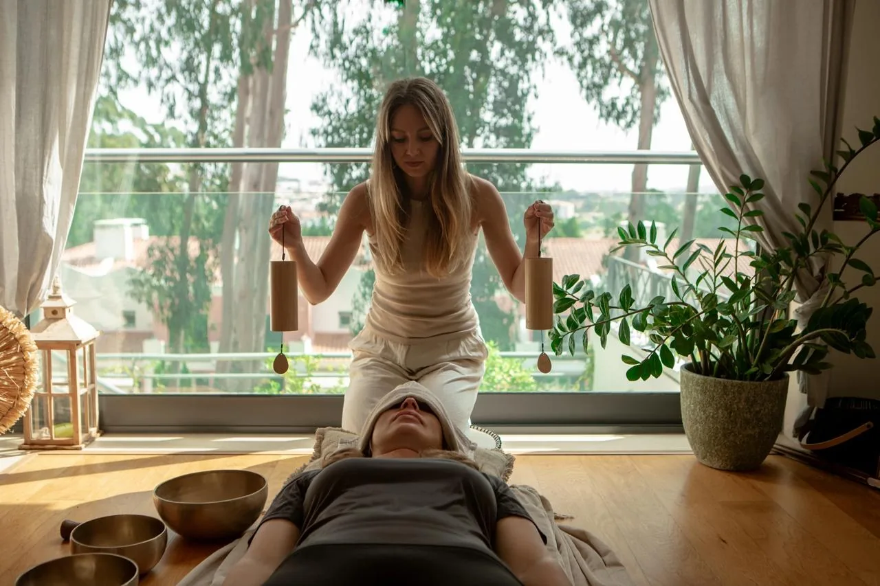 Acalia practitioner offering a sound ritual in a sunlit Lisbon room